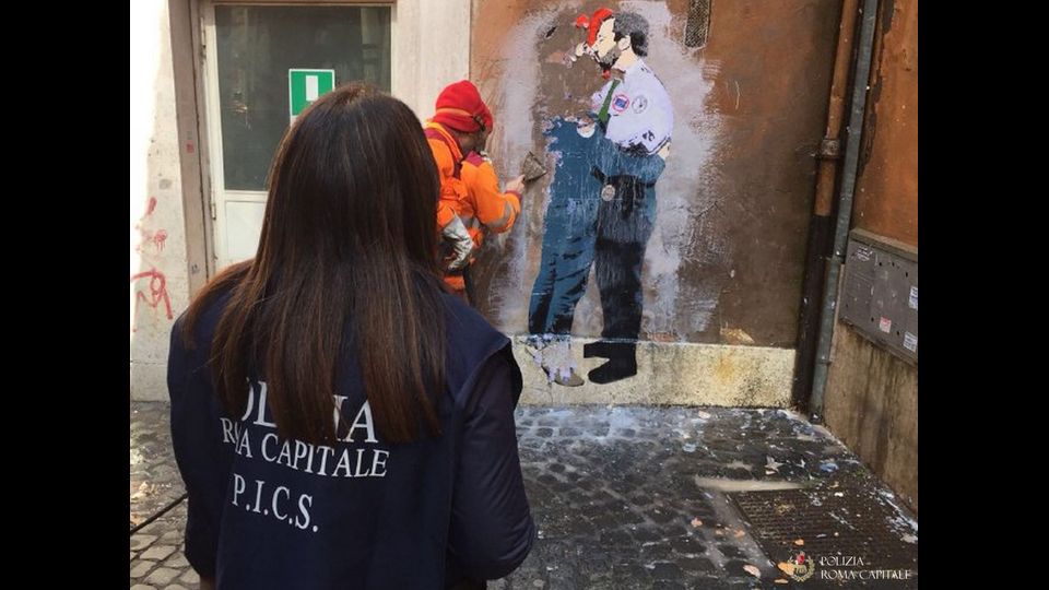 Lo street artist TVBOY realizza dei poster nel centro di Roma. Nella foto la Sezione Pronto Intervento Centro Storico della capitale cancella i murales
