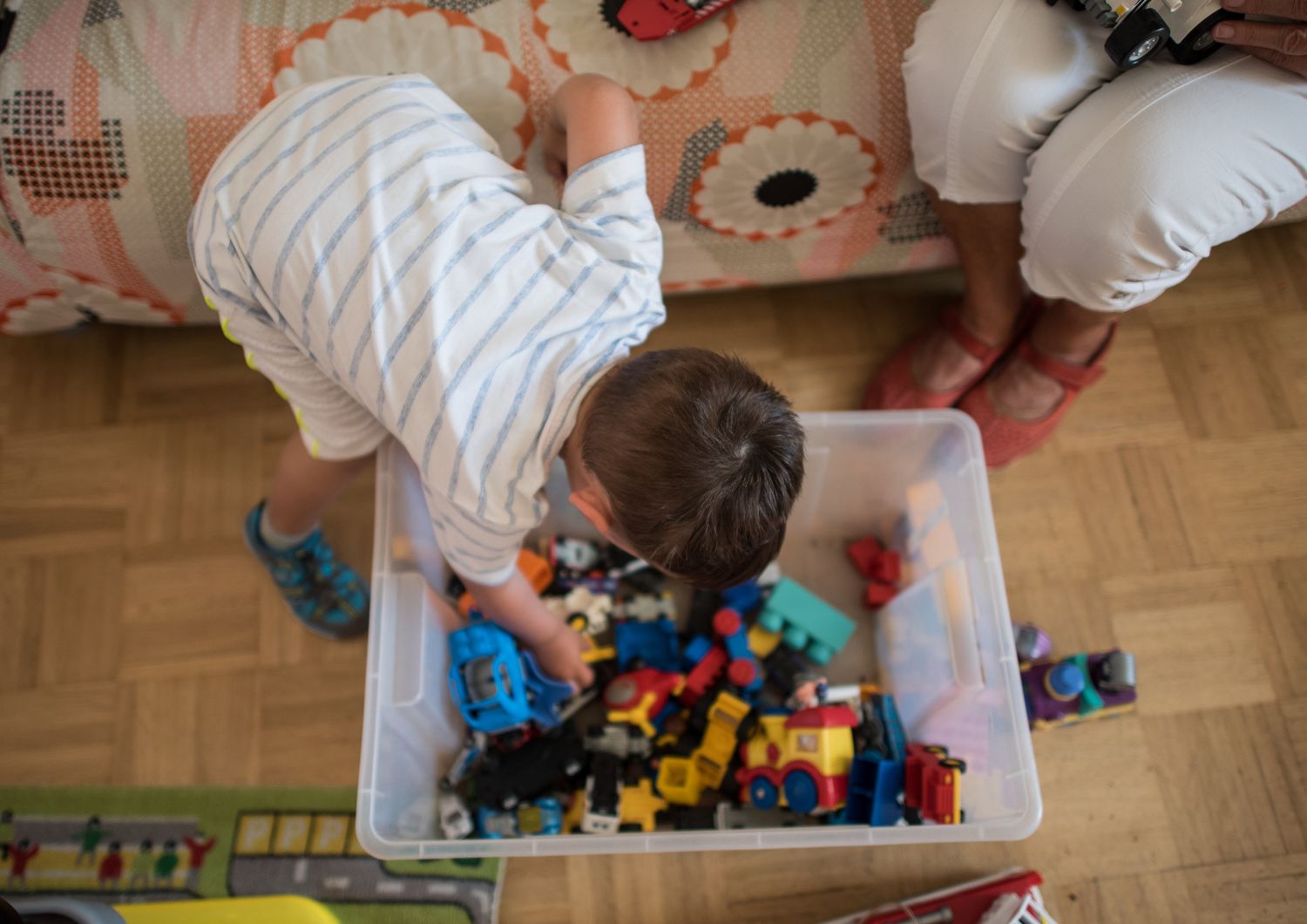 &nbsp;Un bambino di due anni alle prese con una scatola piena di giocattoli