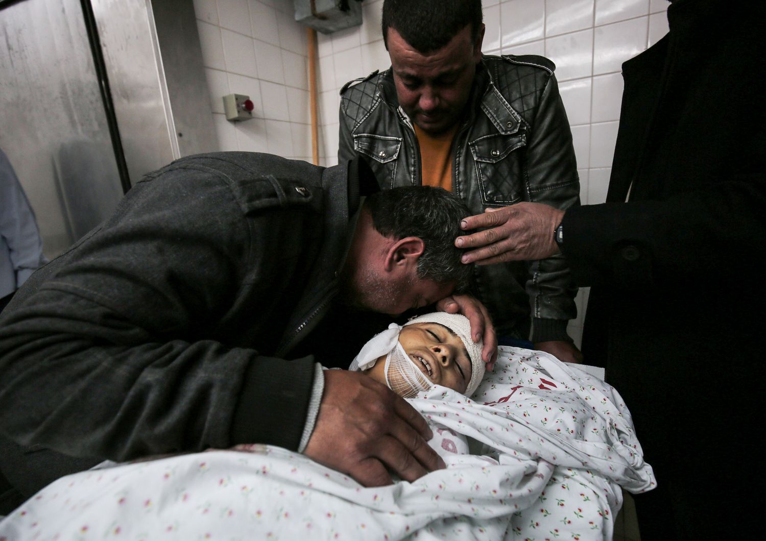 Parenti del 15enne palestinese Azzam Oweida piangono attorno al suo corpo