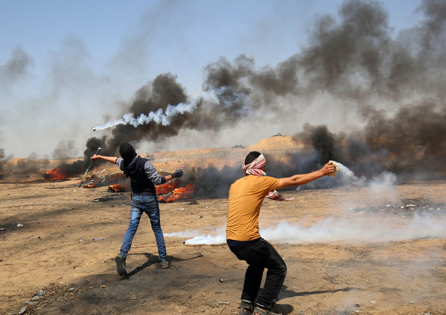 Manifestante che usano &nbsp;racchette e fionde per rispondere alle truppe israeliane durante gli scontri lungo il confine con la striscia di Gaza&nbsp;