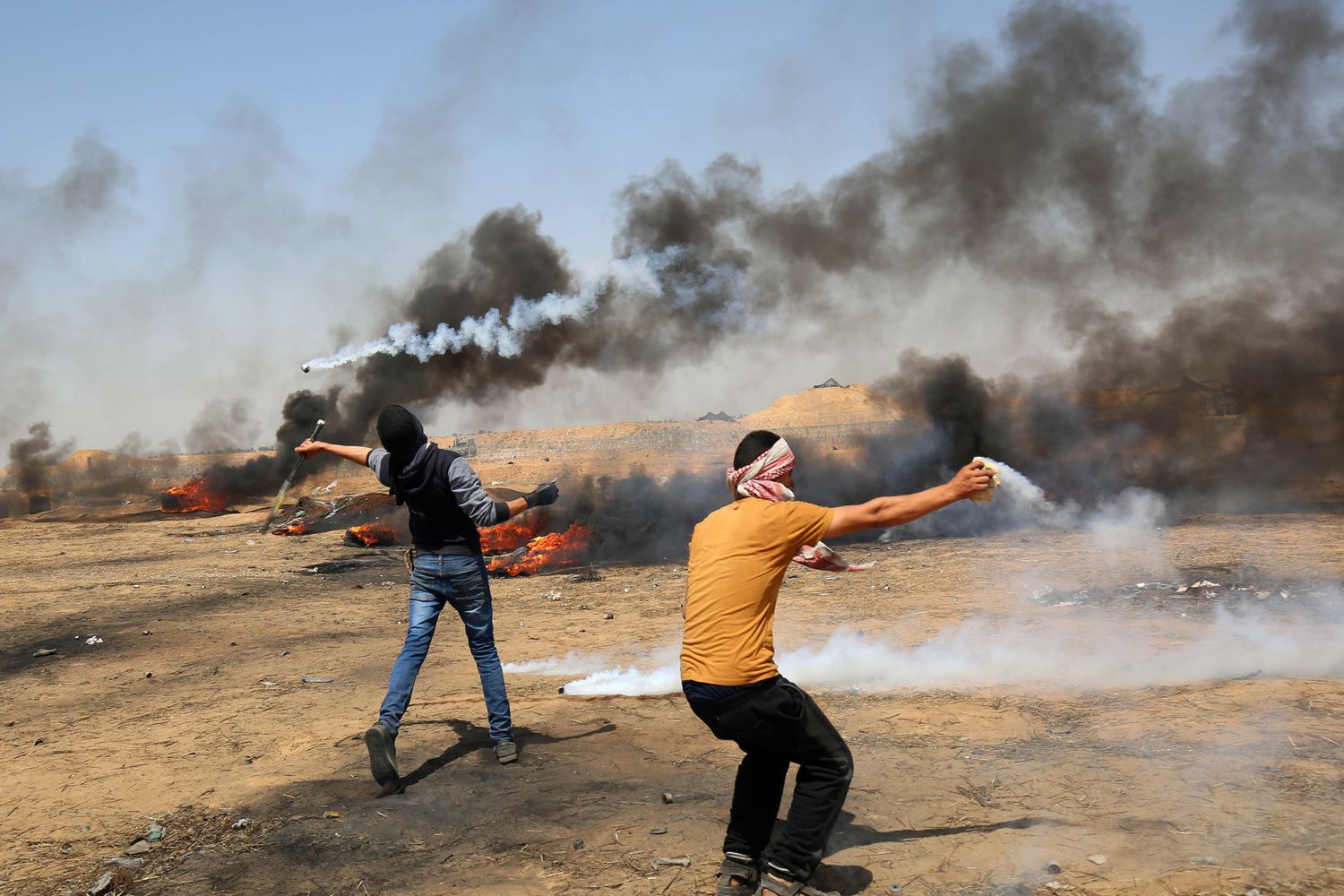 Manifestante che usano &nbsp;racchette e fionde per rispondere alle truppe israeliane durante gli scontri lungo il confine con la striscia di Gaza&nbsp;