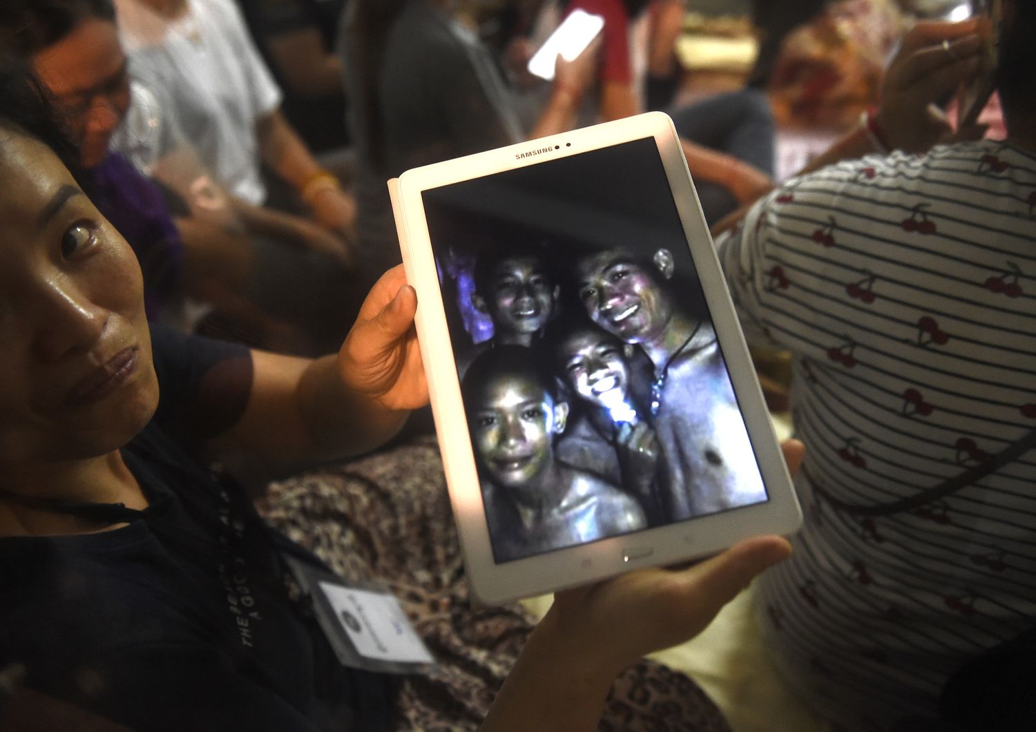 &nbsp;Un familiare mostra le immagini dei ragazzi trovati vivi nella grotta in Thailandia