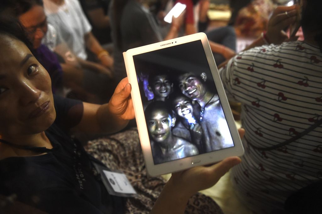 &nbsp;Un familiare mostra le immagini dei ragazzi trovati vivi nella grotta in Thailandia