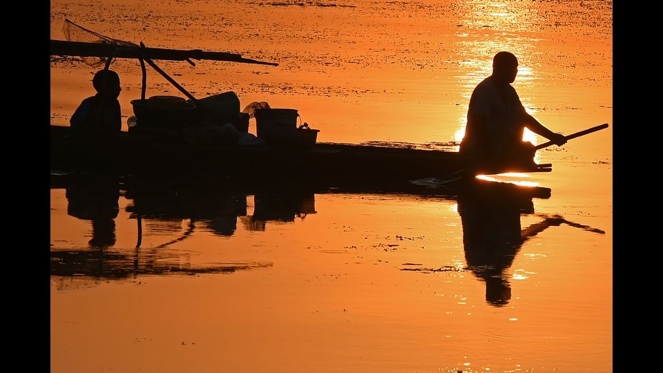 Un pescatore del Kashmir rema la sua barca durante il tramonto sul lago dal a Srinagar il 12 settembre 2018
