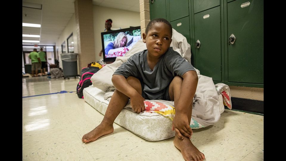 Un bambino siede su un materasso in un rifugio per l'evacuazione di Hurricane a Conway High School il 13 settembre 2018 a Conway, in South Carolina.