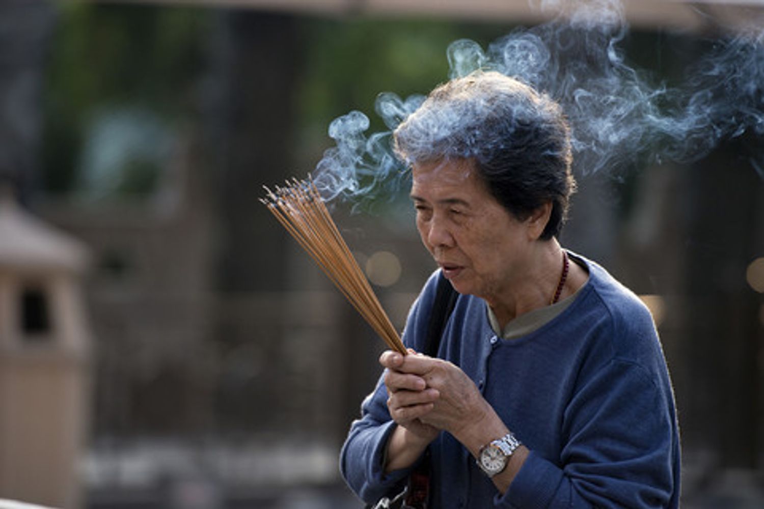 A woman prays holding incense sticks at the Wong Tai Sin temple in Hong Kong on October 28, 2013. The Taoist temple is a major tourist attraction and centre for worship in Hong Kong, and attracts thousands of visitors each year especially around the Chinese New Year holiday.&nbsp;