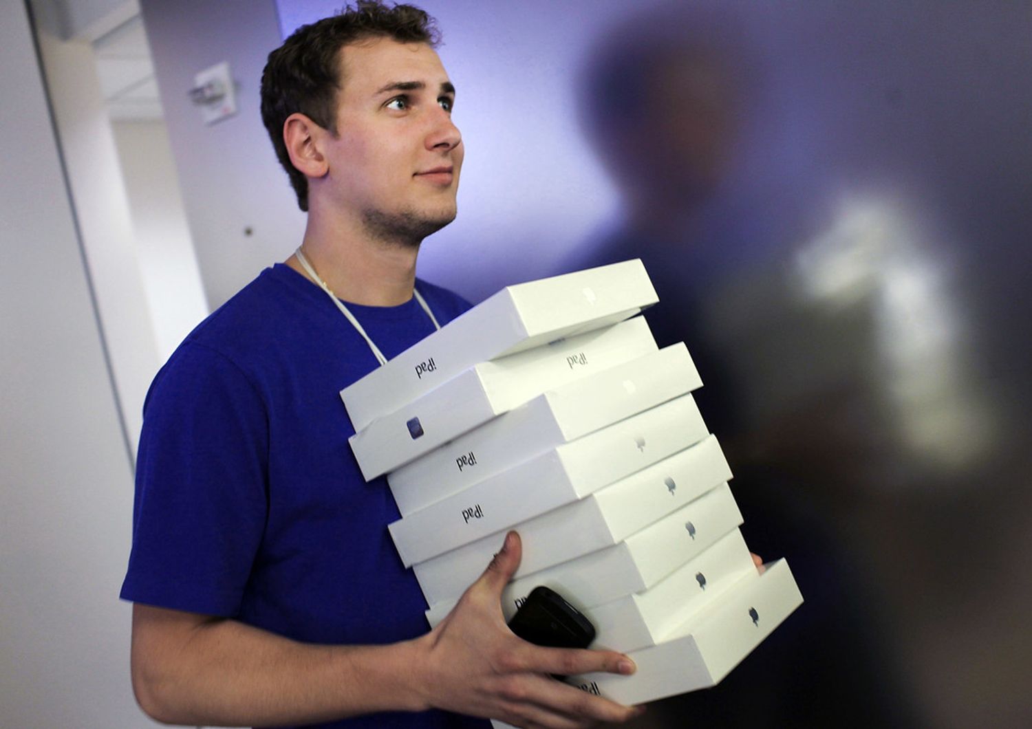 &nbsp;Un dipendente Apple con una pila di confezioni di iPad