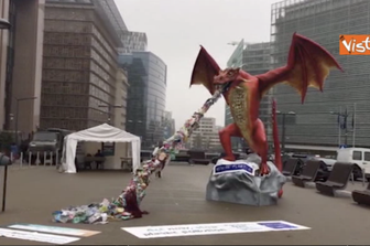 Il drago di cartapesta che sputa rifiuti di plastica davanti al al Consiglio UE a Bruxelles