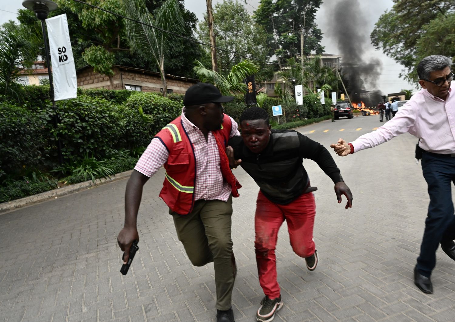 Un ferito nell'attentato di Nairobi viene portato via da un agente di polizia