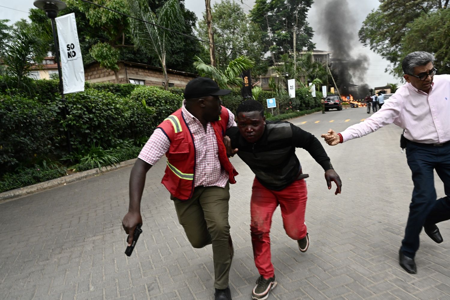 Un ferito nell'attentato di Nairobi viene portato via da un agente di polizia
