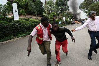 Un ferito nell'attentato di Nairobi viene portato via da un agente di polizia