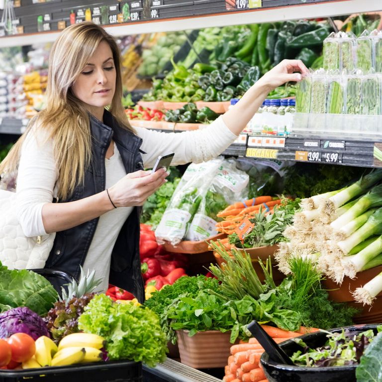 La spesa al supermercato valutando i cibi con lo smartphone