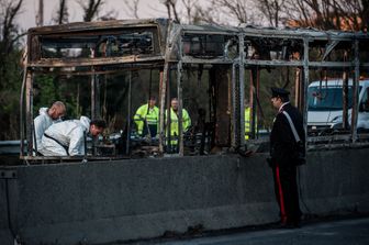 I resti dello scuolabus dato alle fiamme