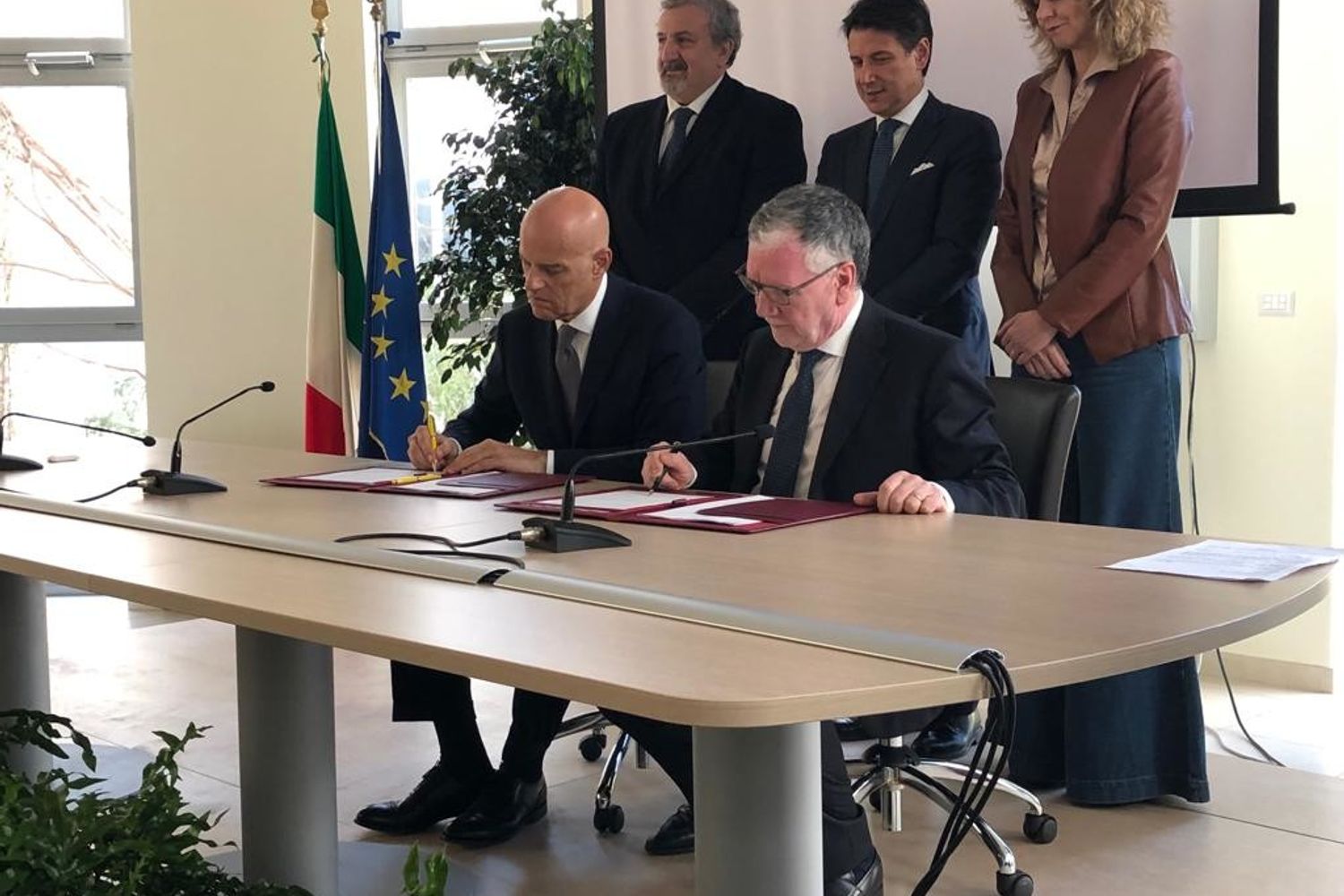la firma tra Claudio Descalzi e Massimo Inguscio. Nella foto anche il governatore della Puglia Michele Emiliano, il premier Giuseppe Conte e la ministra per il Sud, Barbara Lezzi