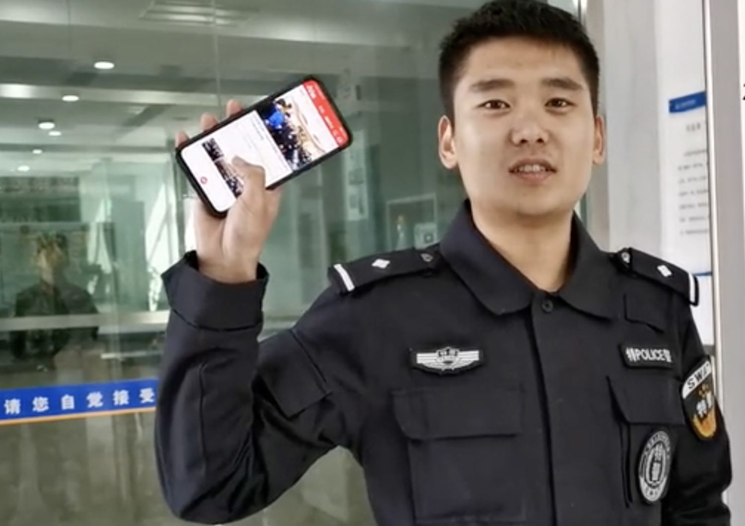 Una guardia mostra con orgoglio il telefonino dove sta usando la app Studia la Grande Nazione