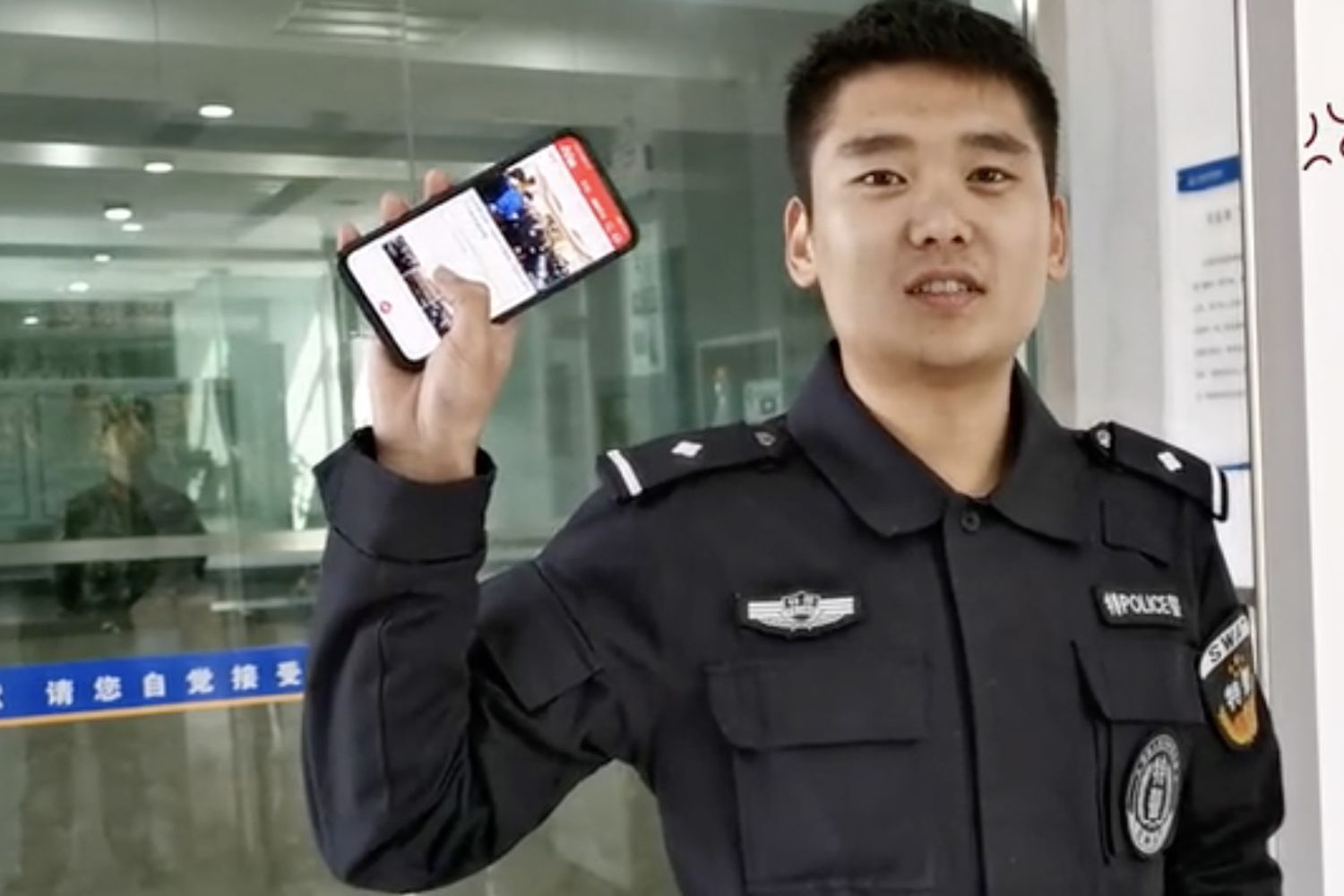 Una guardia mostra con orgoglio il telefonino dove sta usando la app Studia la Grande Nazione