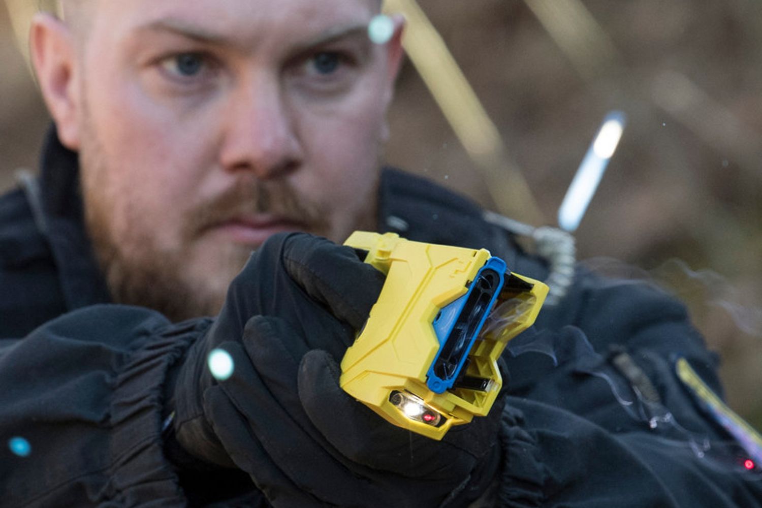 Un poliziotto punta una pistola elettrica (Taser)