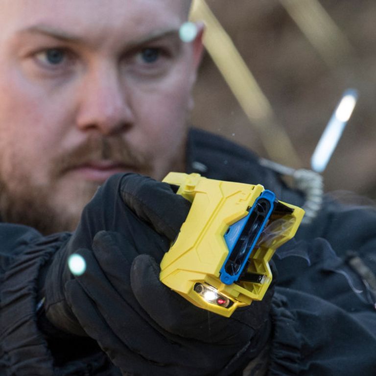 Un poliziotto punta una pistola elettrica (Taser)