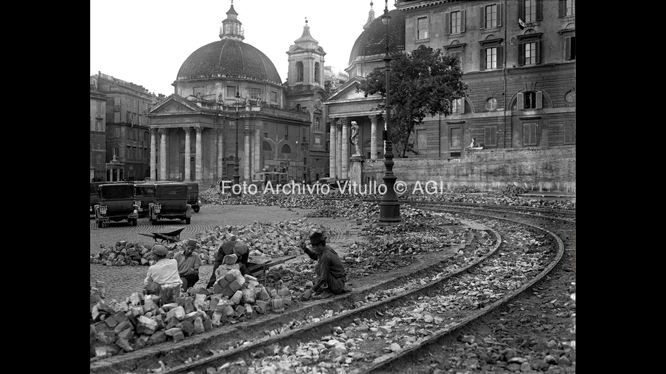 Raccolta rottami di ferro dai binari del tram ormai dismesso in piazza del Popolo (1935)