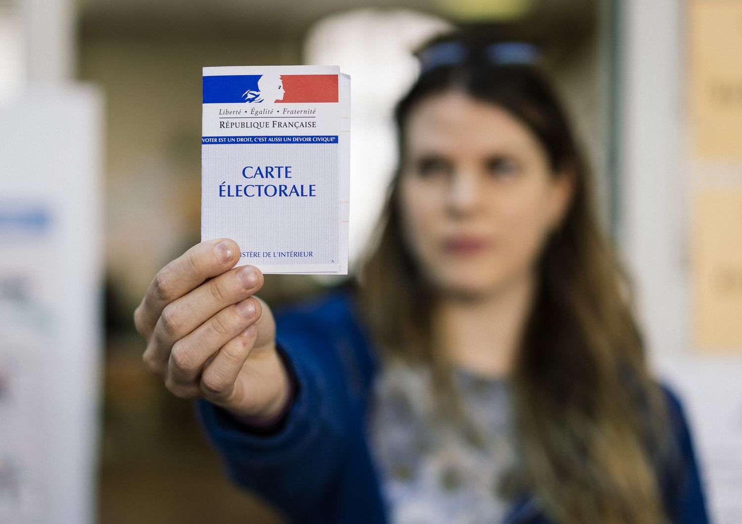 Una donna francese mostra la sua tessera elettorale dopo aver votato alle Europee del 2019