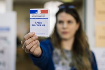 Una donna francese mostra la sua tessera elettorale dopo aver votato alle Europee del 2019