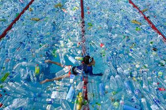 Un bambino nuota in una piscina piena di plastica: parte di una campagna contro l'Inquinamento a Bangkok