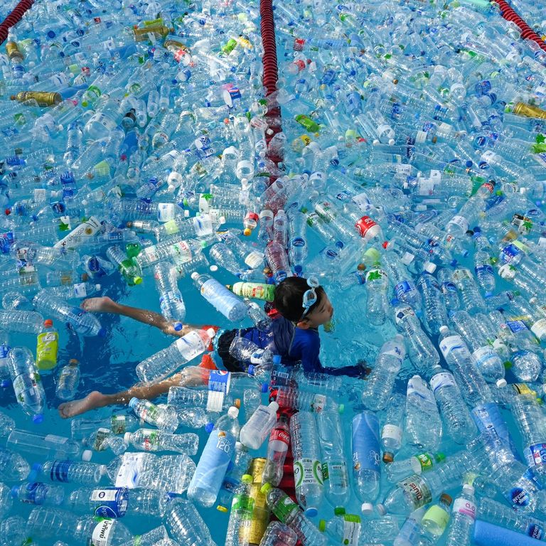 Un bambino nuota in una piscina piena di plastica: parte di una campagna contro l'Inquinamento a Bangkok