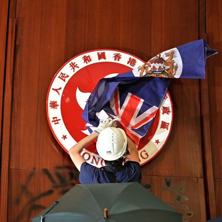 Manifestanti nel Parlamento di Hong Kong issano sul muro dell'aula la bandiera coloniale britannica