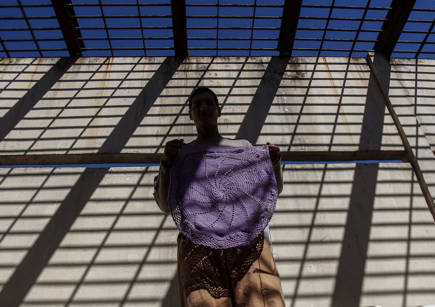 Un detenuto mostra un lavoro all'uncinetto fatto nell'ambito di un programma di riabilitazione in un carcere brasiliano