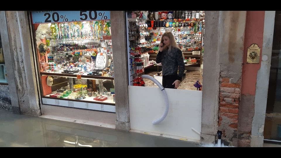Gli sbarramenti eretti dai negozi per tenere fuori l'acqua alta a Venezia