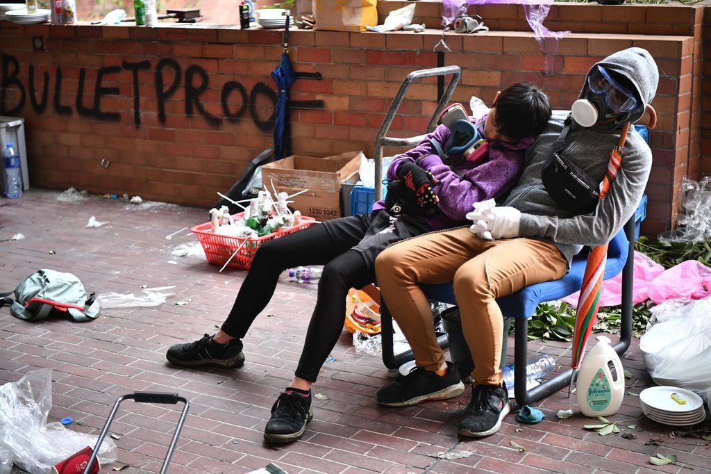 Manifestanti riposano durante la tregua nell'assedio al PolyU di Hong Kong