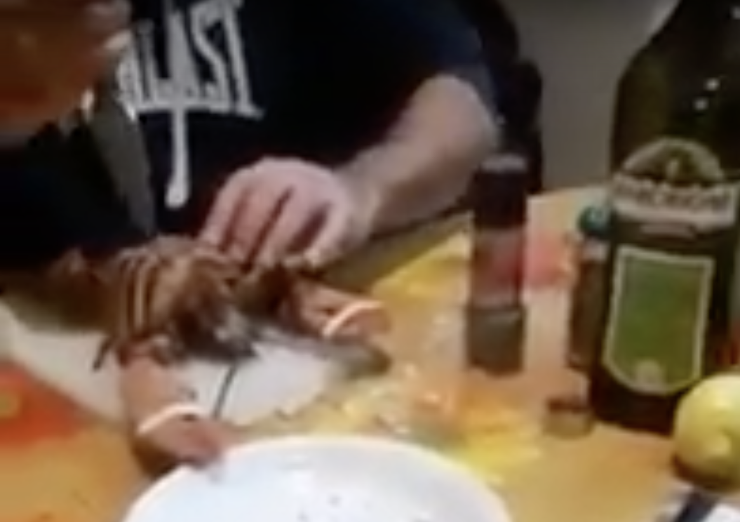 Un fotogramma del video in cui un uomo scanna un'aragosta viva