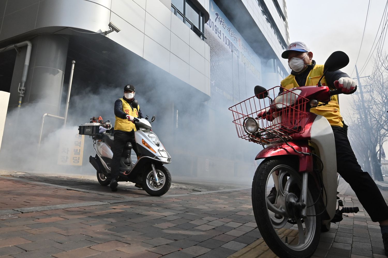 Personale sanitario spruzza disinfettante all'esterno della sede della setta