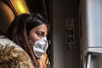 Una passeggera di un treno con la mascherina alla fermata di Porta Garibaldi a Milano