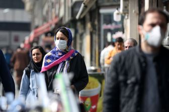 Con la mascherina per le strade di Teheran per paura del coronavirus