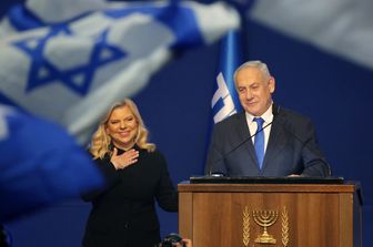 Il premier Benjamin Netanyahu sul palco con la moglie Sara saluta i sostenitori a Tel Aviv dopo la vittoria.