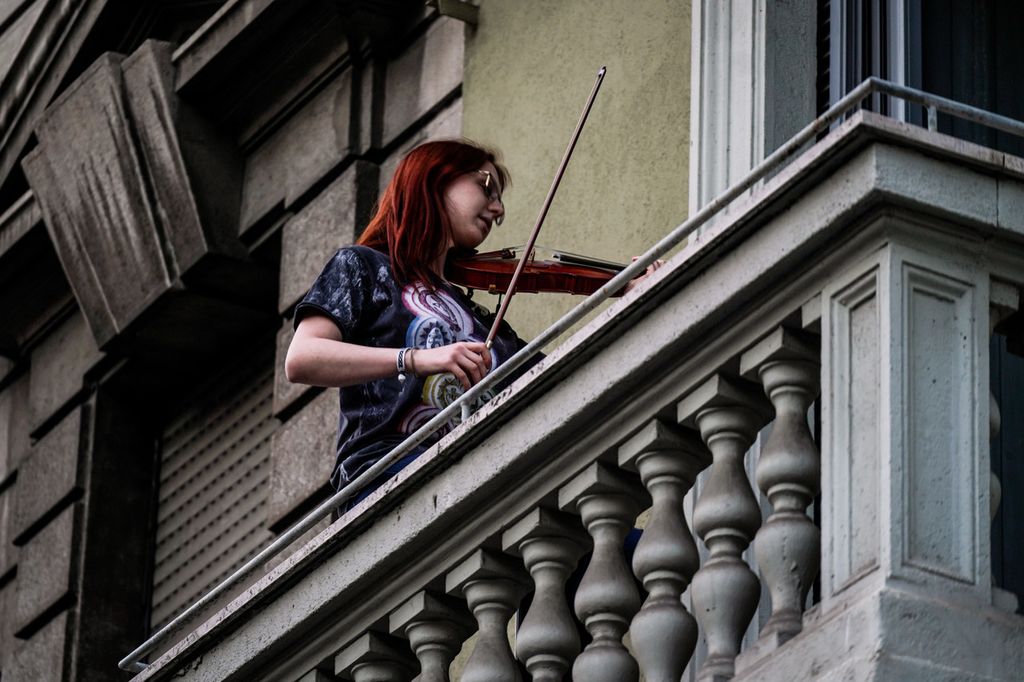 Una violinista partecipa al flashmob per combattere l'isolamento da coronavirus