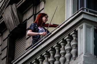 Una violinista partecipa al flashmob per combattere l'isolamento da coronavirus