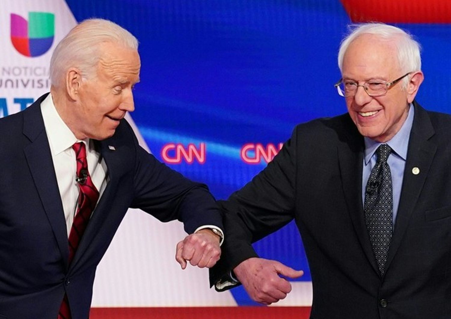 Joe Biden e Bernie Sanders si danno di gomito per non stringersi la mano in tempi di coronavirus