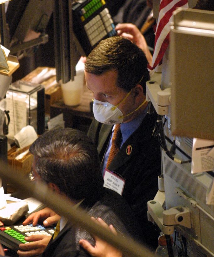 Un trader con una mascherina a Wall Street