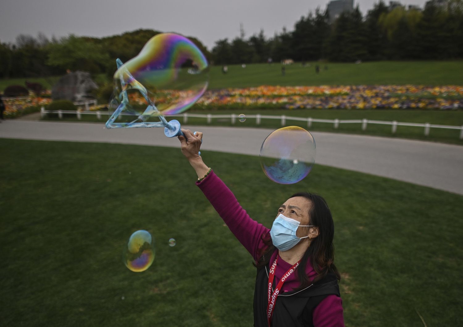 Una donna fa le bolle di sapone in un parco di Shanghai