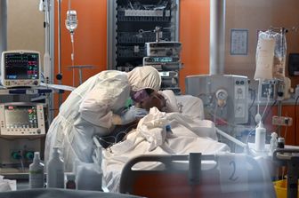 Un medico assiste un paziente in una unit&agrave; Covid-19 di un ospedale romano