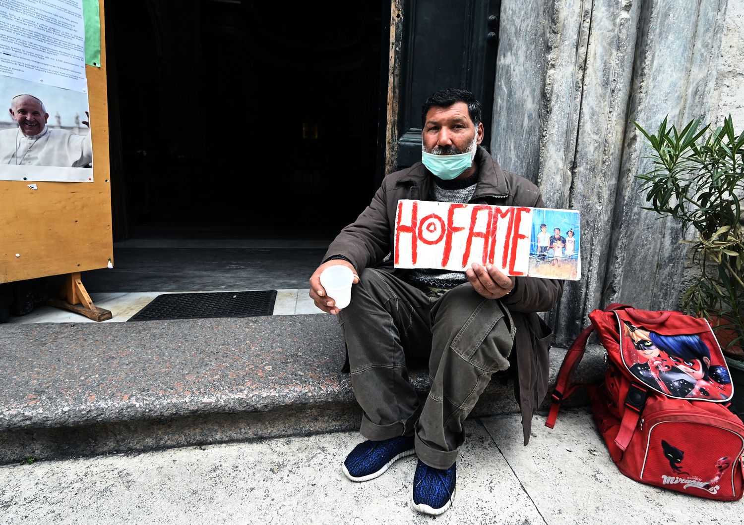 Un mendicante davanti a una chiesa di Roma domenica scorsa