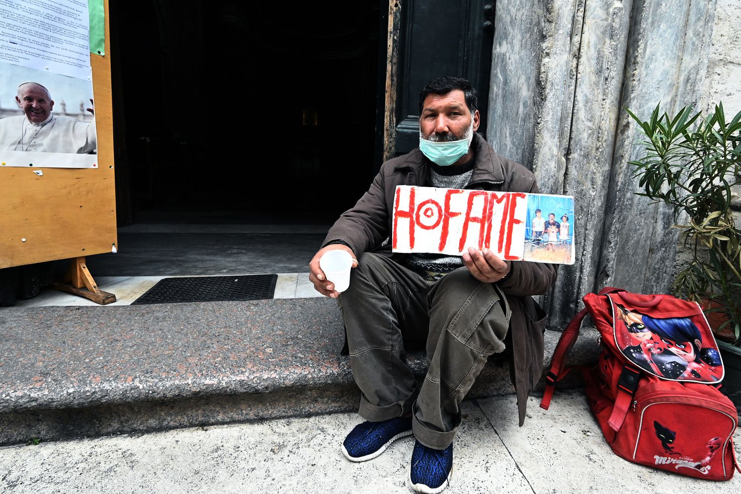 Un mendicante davanti a una chiesa di Roma domenica scorsa