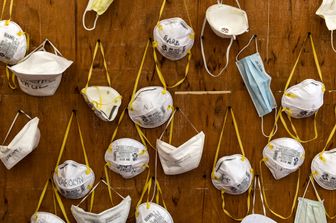 Le mascherine appese in un ospedale italiano portano i nomi dei medici che sono costretti a riutilizzarle