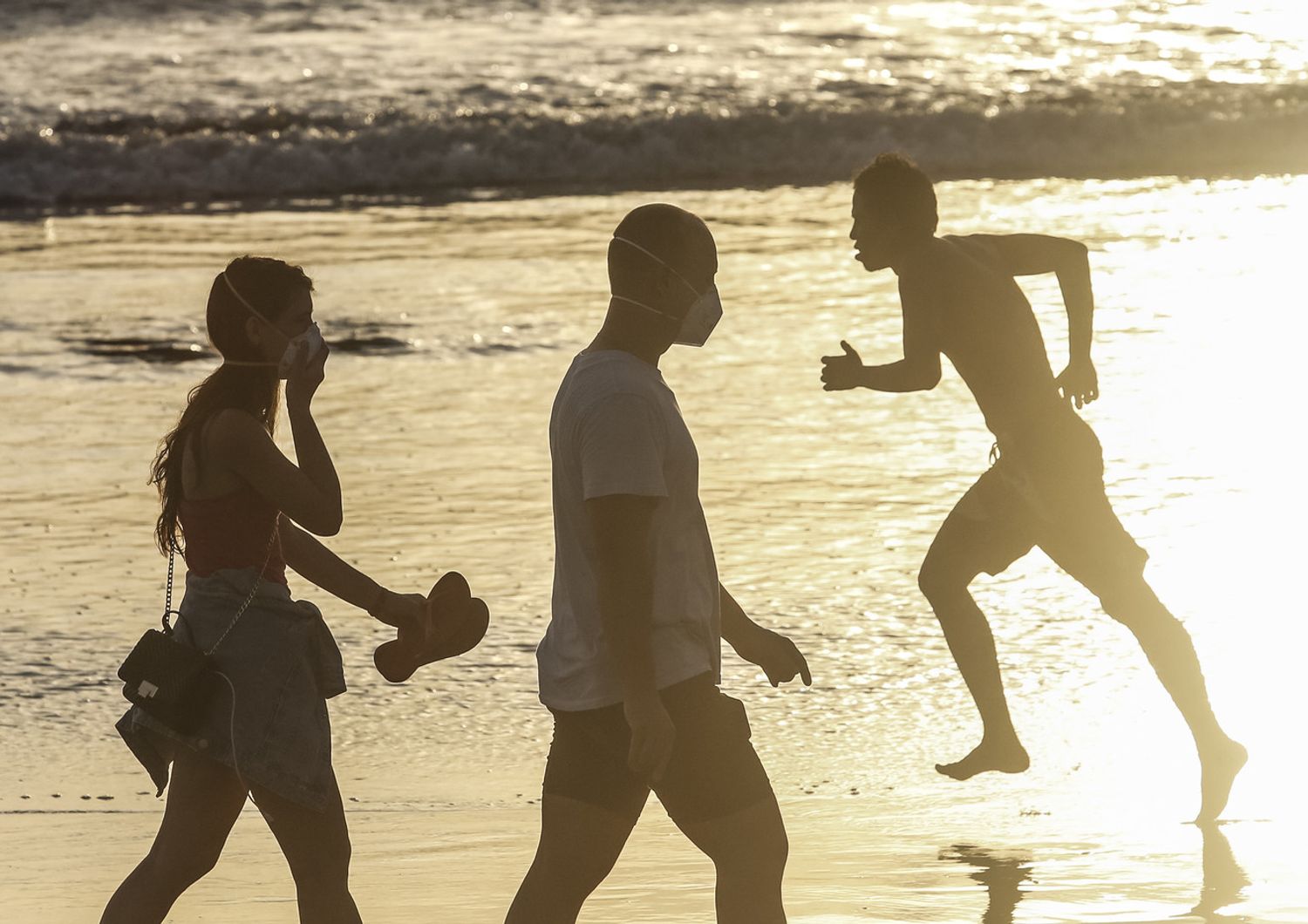 Bagnanti con la mascherina a Bali. Secondo l'epidemiologo, l'uso entrer&agrave; nelle nostre abitudini anche passata l'emergenza coronavirus