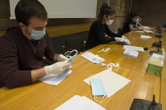 Volontari distribuiscono le mascherine arrivate in Lombardia