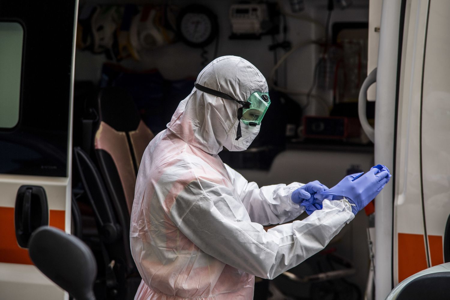 Un sanitario si prepara a prelevare un malato di coronavirus per caricarlo in ambulanza