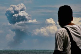 Un uomo osserva la colonna di cenere del vulcano Anak Krakatau dalla citt&agrave; indonesiana di Serang