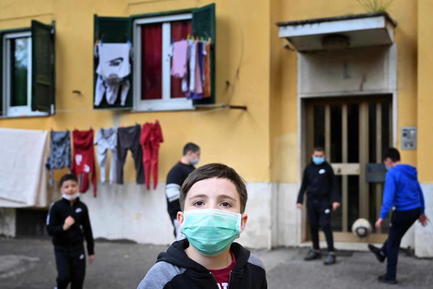 Un gruppo di bambini gioca in un cortile nel quartiere di San Basilio, nella Roma isolata per il coronavirus